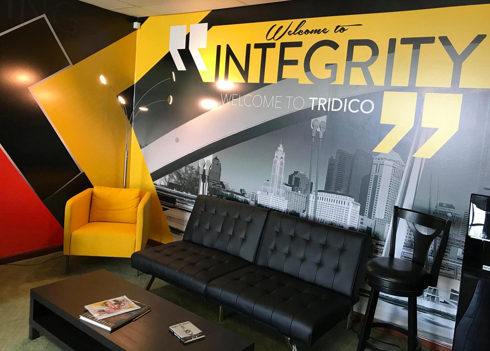 Tridico Design office wall with brand colors and motto